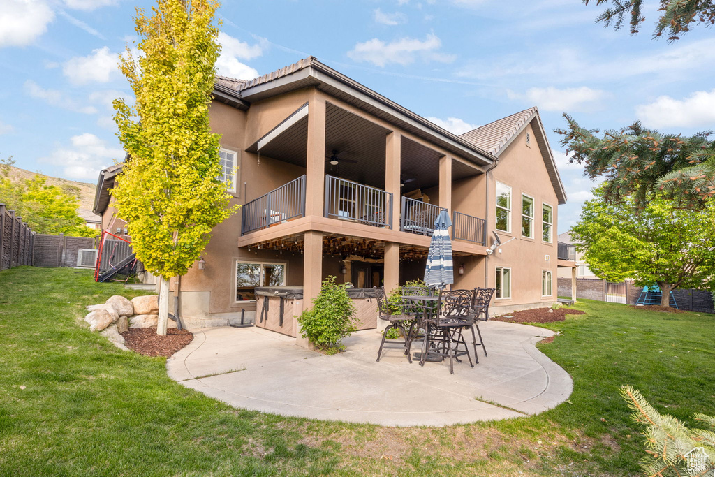 Back of house featuring a balcony, a ceiling fan, stucco siding, and a patio area