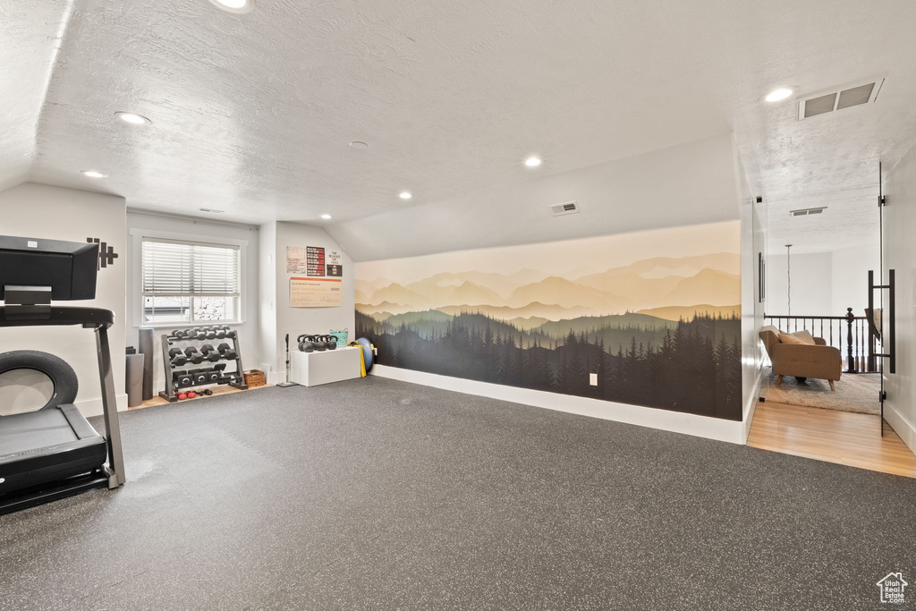 Workout area with lofted ceiling, recessed lighting, a textured ceiling, and baseboards