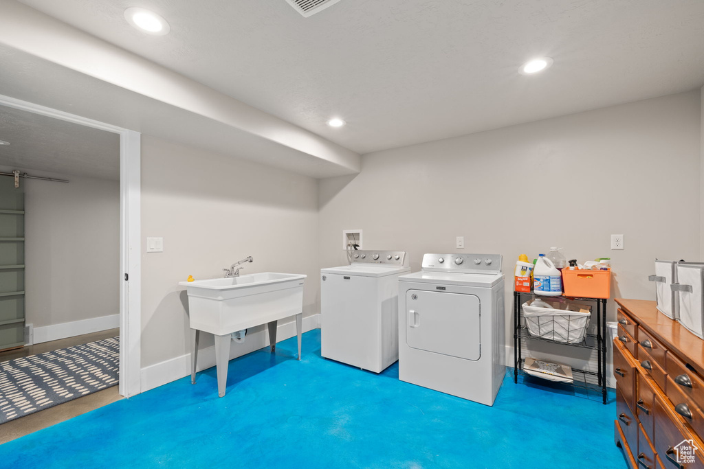 Clothes washing area featuring washer and clothes dryer, recessed lighting, and baseboards