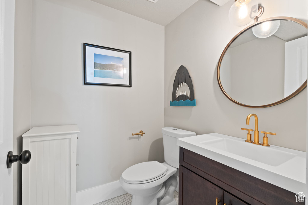 Bathroom featuring toilet, vanity, and baseboards