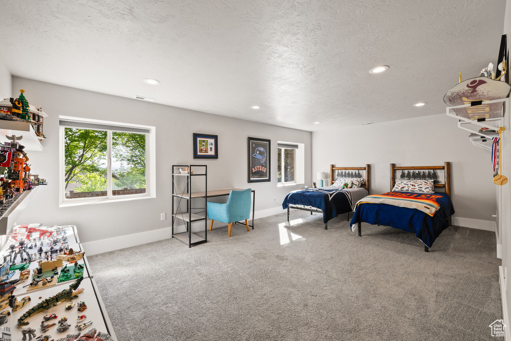 Carpeted bedroom featuring recessed lighting, baseboards, and a textured ceiling