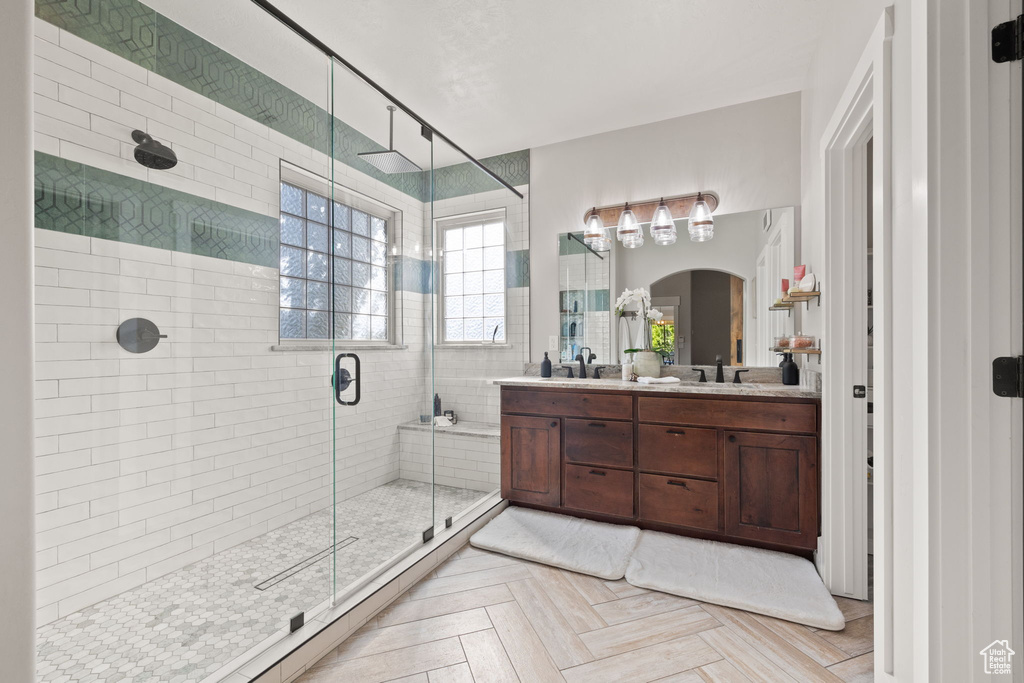 Full bathroom featuring a stall shower and double vanity