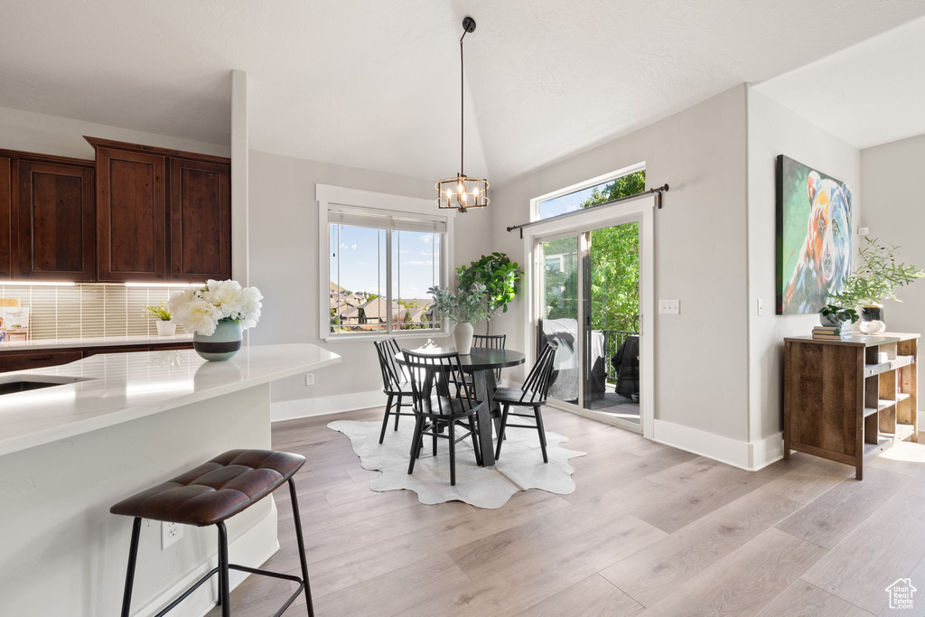 Dining room featuring baseboards, light wood-type flooring, and a chandelier