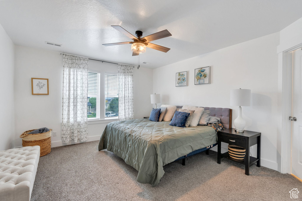 Carpeted bedroom featuring baseboards and a ceiling fan