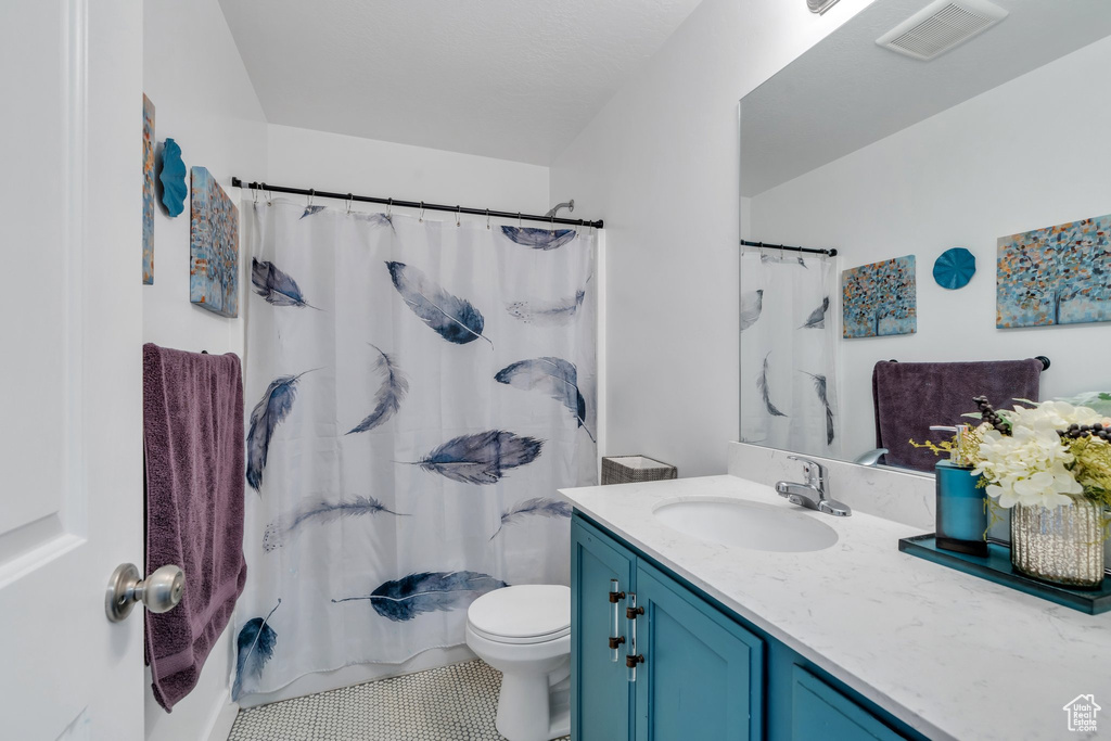 Full bath featuring vanity, toilet, and tile patterned floors