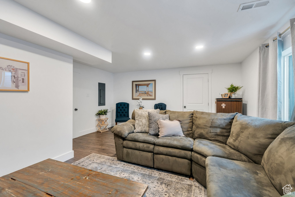 Living area featuring recessed lighting, dark wood finished floors, baseboards, and electric panel