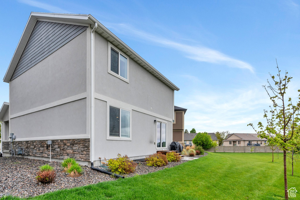 Rear view of house with stucco siding and stone siding