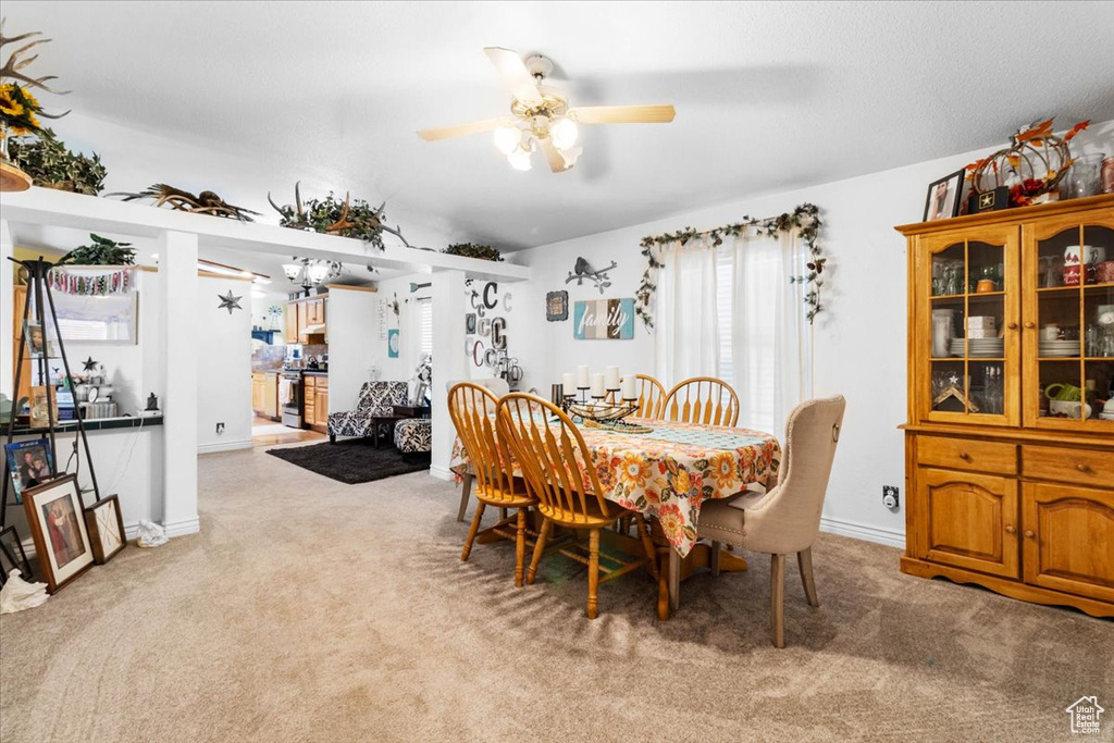 Dining room with carpet, ceiling fan, and baseboards