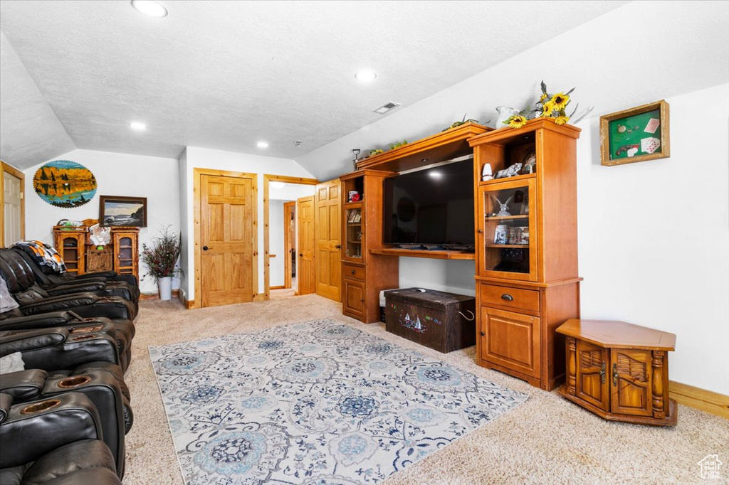 Living area featuring vaulted ceiling, light colored carpet, recessed lighting, and baseboards