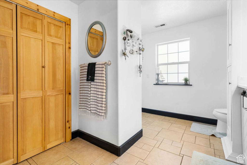 Hall featuring baseboards and light tile patterned flooring