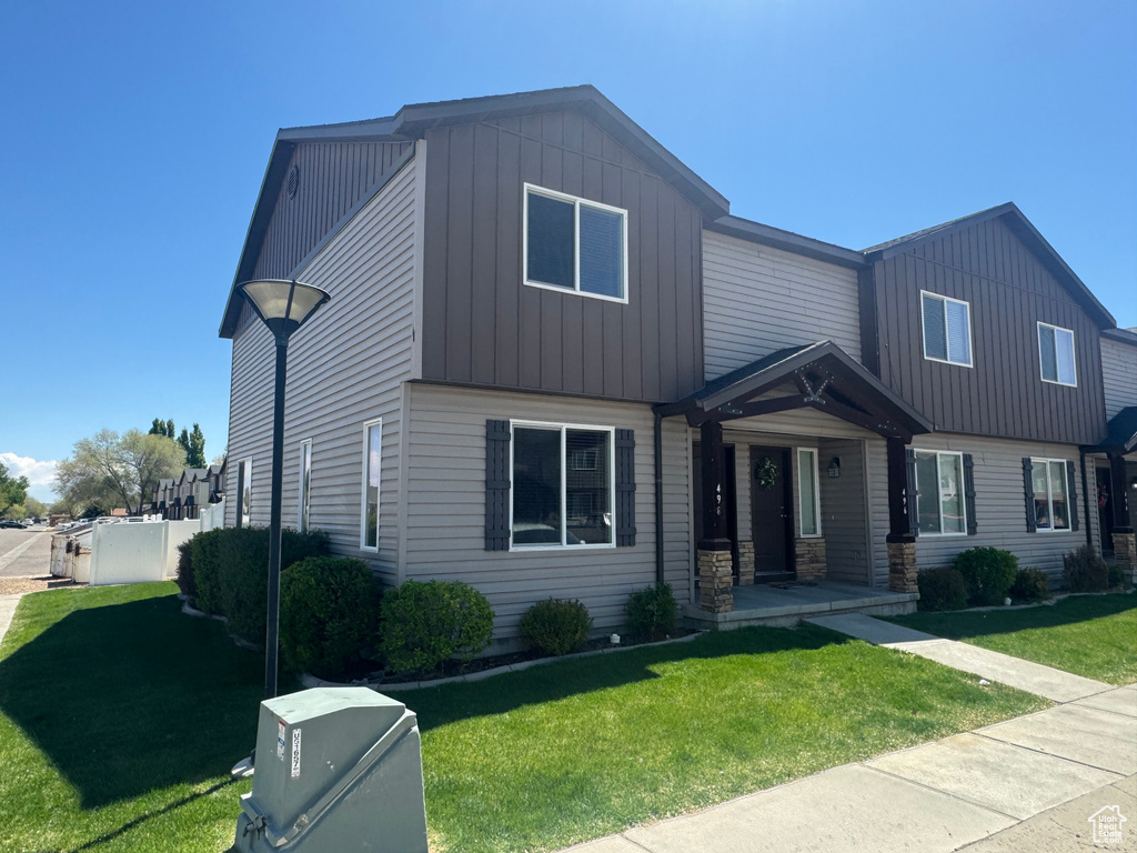 View of front of house featuring board and batten siding and a front lawn