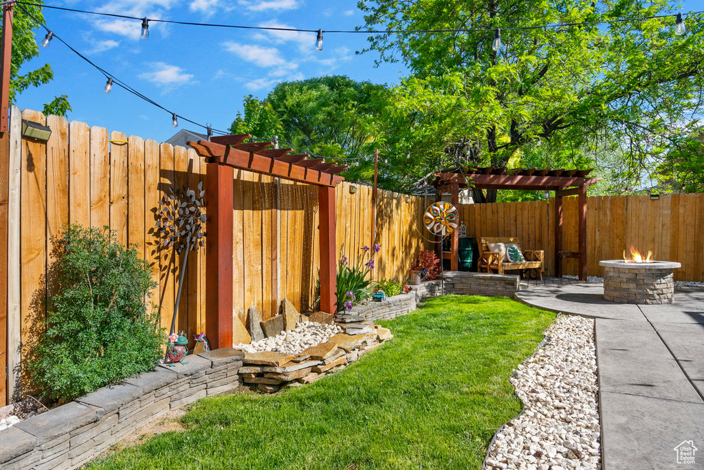 View of yard featuring an outdoor fire pit and a patio area