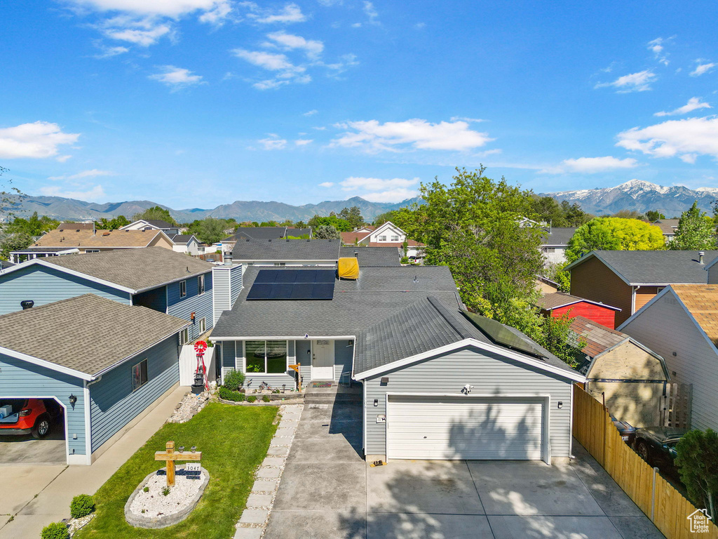 View of front of home featuring a mountain view, a residential view, a garage, and driveway