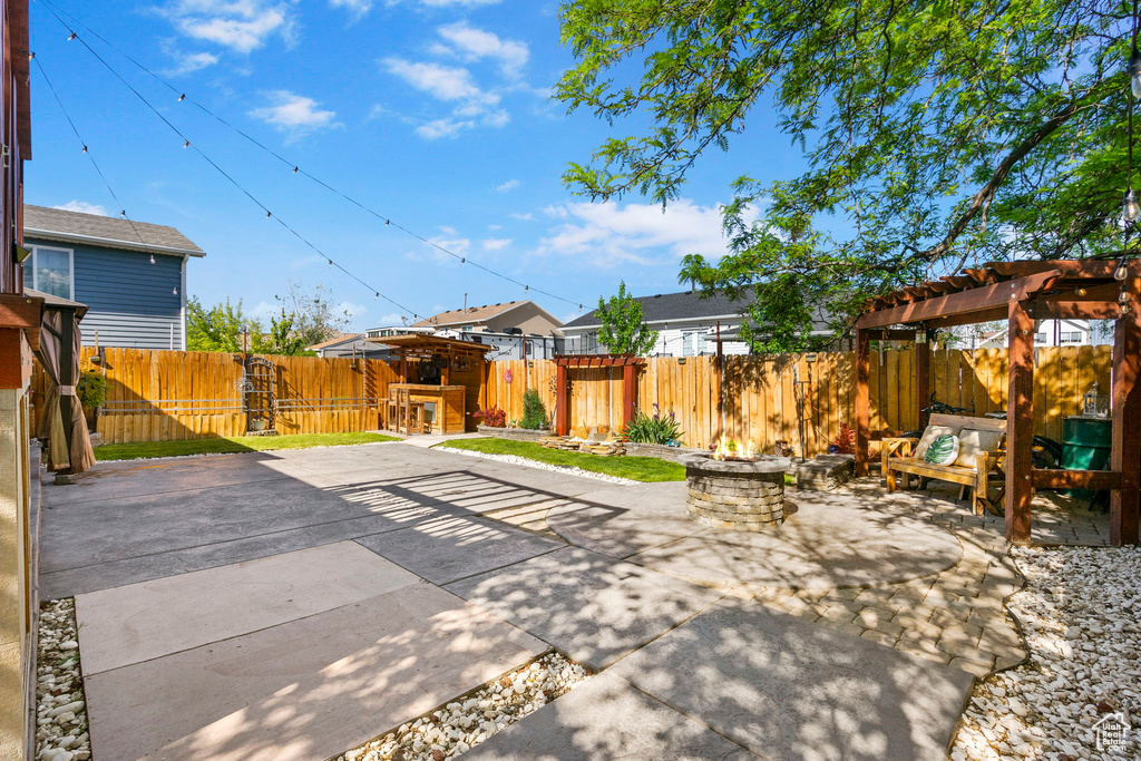 View of patio with a fenced backyard, an outdoor living space with a fire pit, and a pergola