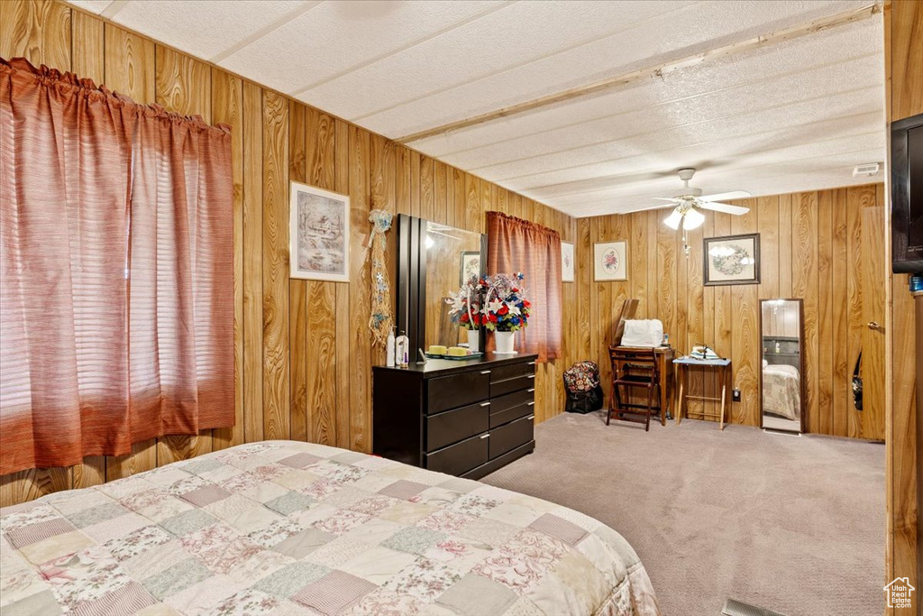 Bedroom with carpet floors and wood walls