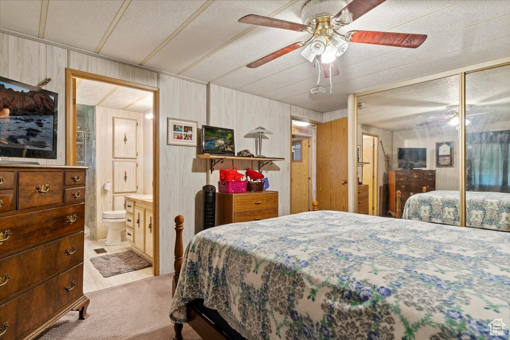 Bedroom with carpet flooring, a closet, connected bathroom, and a ceiling fan