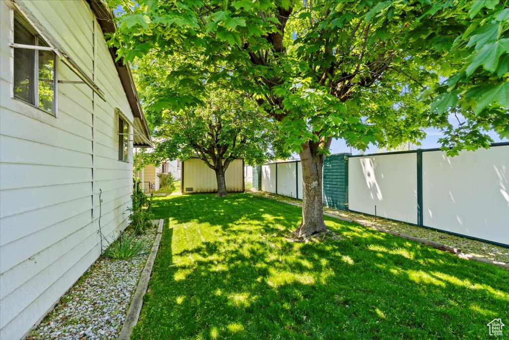 View of yard with an outbuilding and a storage shed