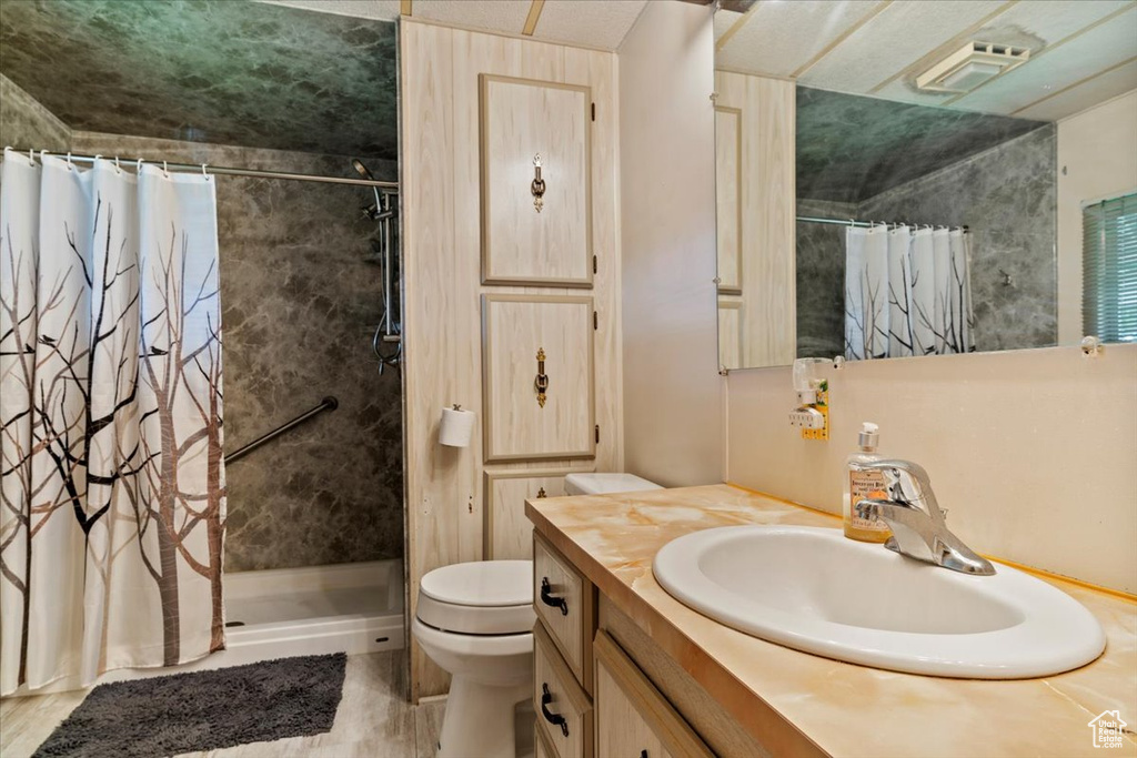 Full bathroom with a shower stall, toilet, and vanity