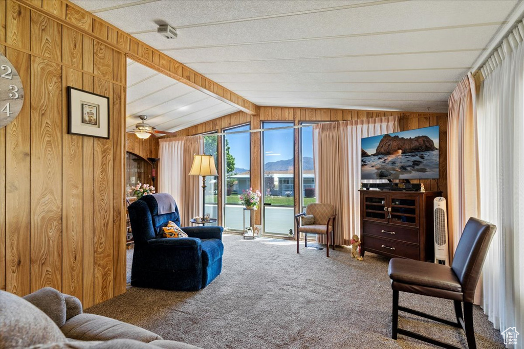 Living room featuring wooden walls, carpet floors, and ceiling fan
