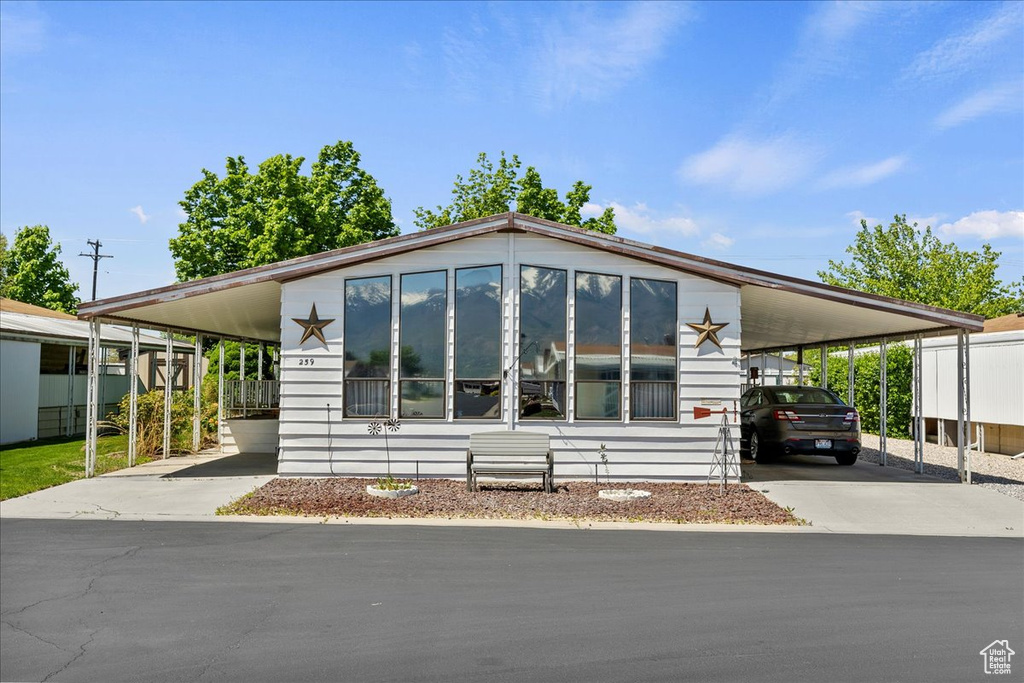 Manufactured / mobile home featuring driveway and an attached carport