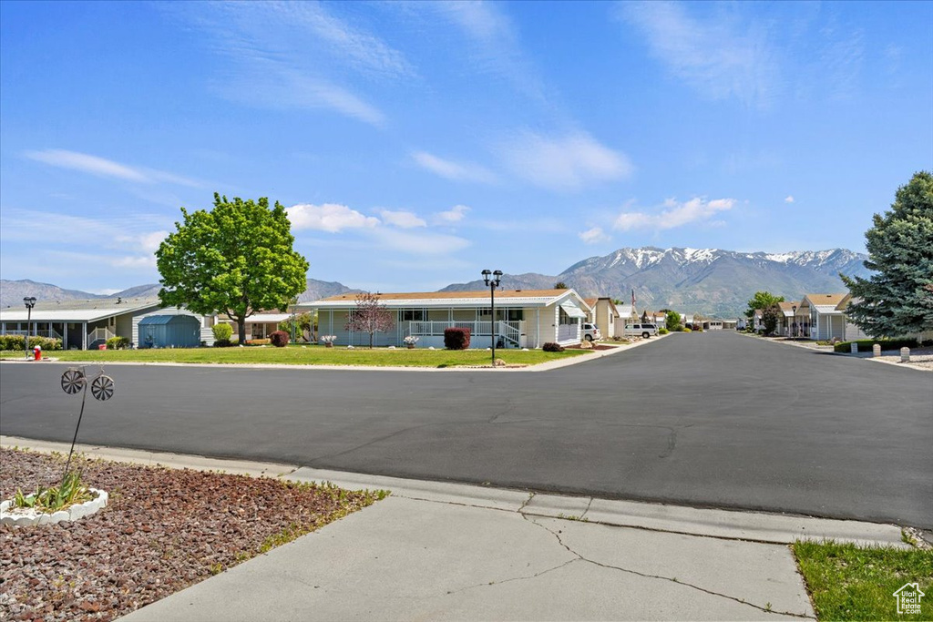 View of asphalt street with a mountain view, street lights, and a residential view