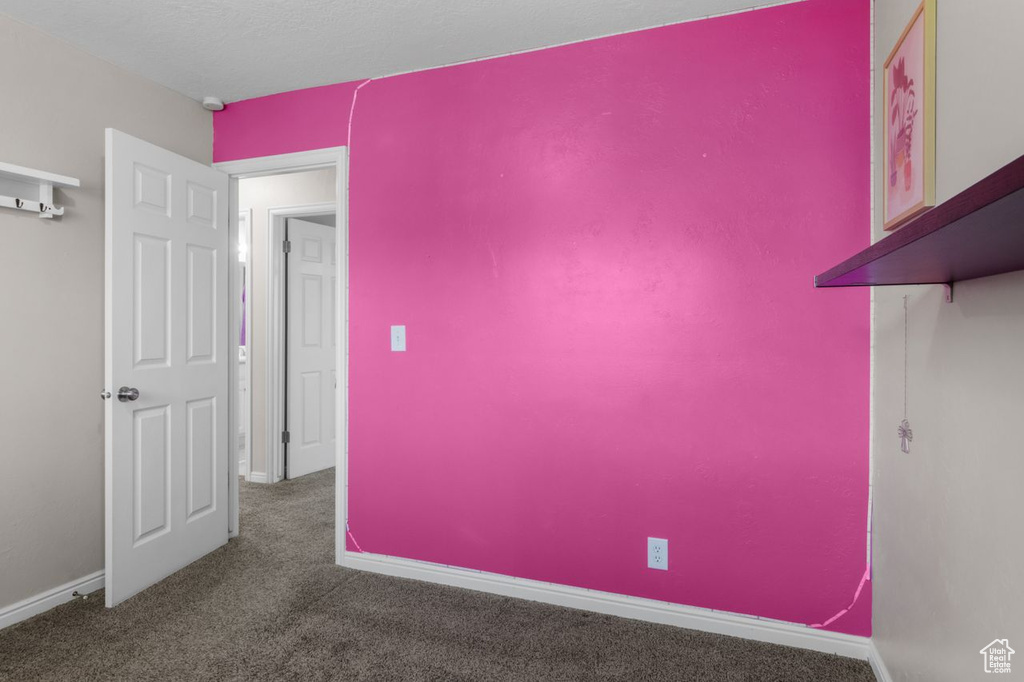 Empty room featuring carpet flooring and baseboards