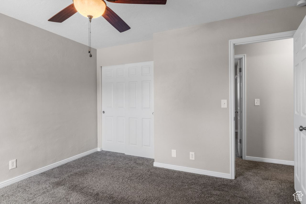 Unfurnished bedroom featuring carpet floors, baseboards, and a ceiling fan