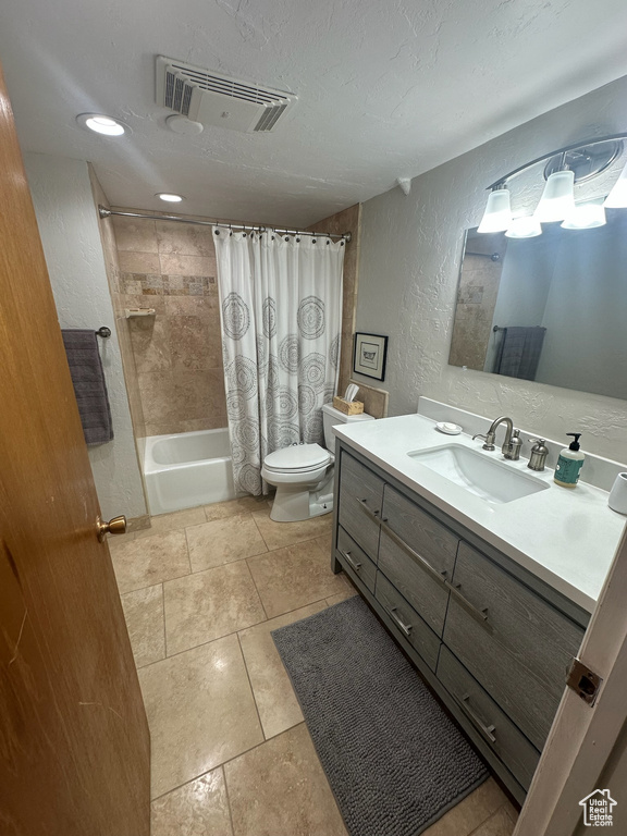 Full bath featuring a textured wall, shower / bath combo, vanity, toilet, and a textured ceiling
