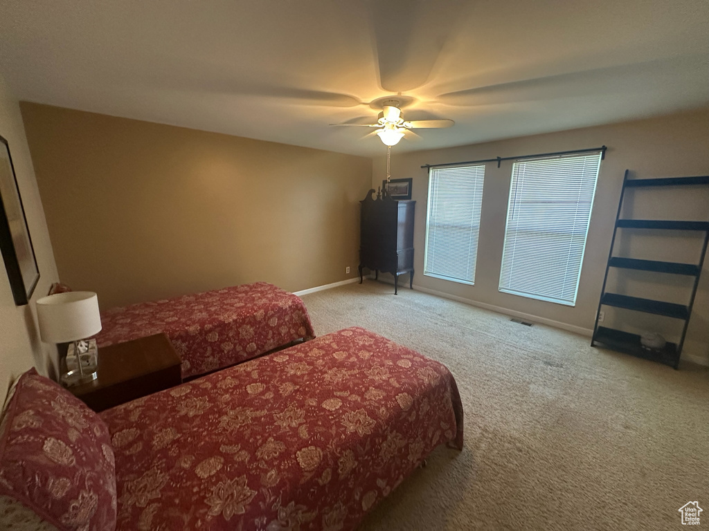 Carpeted bedroom featuring baseboards and a ceiling fan