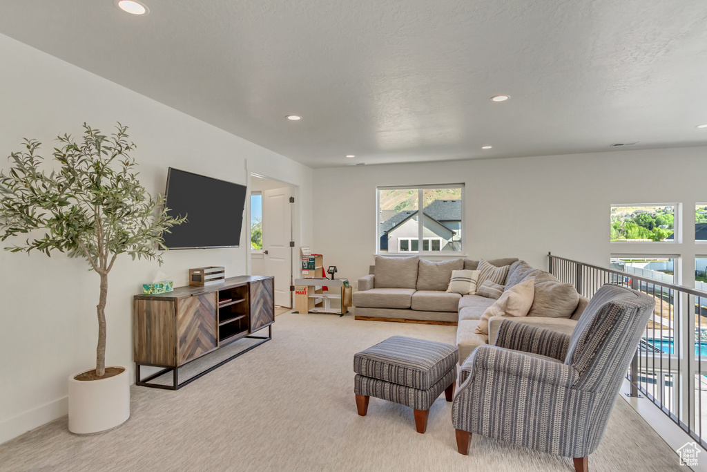 Carpeted living room with recessed lighting and baseboards