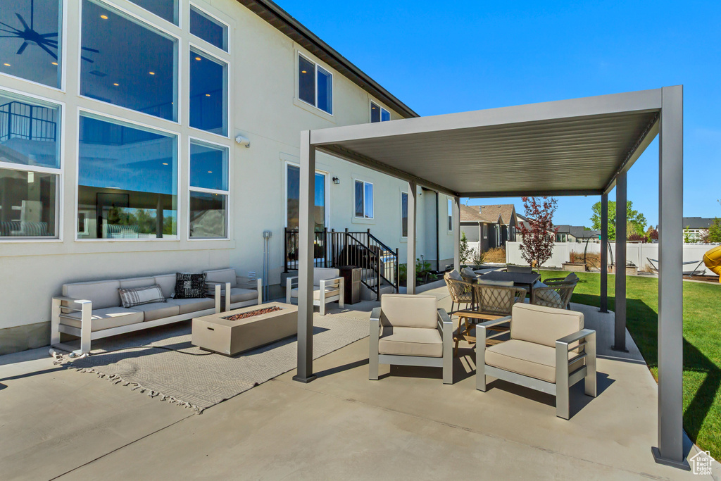 View of patio featuring an outdoor living space with a fire pit