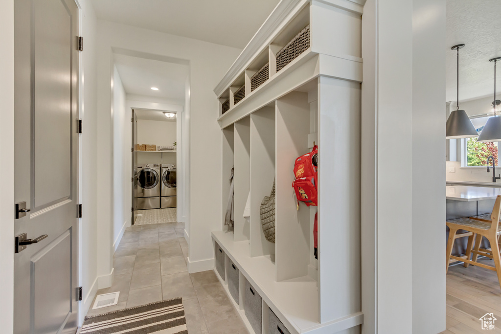 Mudroom featuring independent washer and dryer, a sink, light tile patterned floors, baseboards, and recessed lighting
