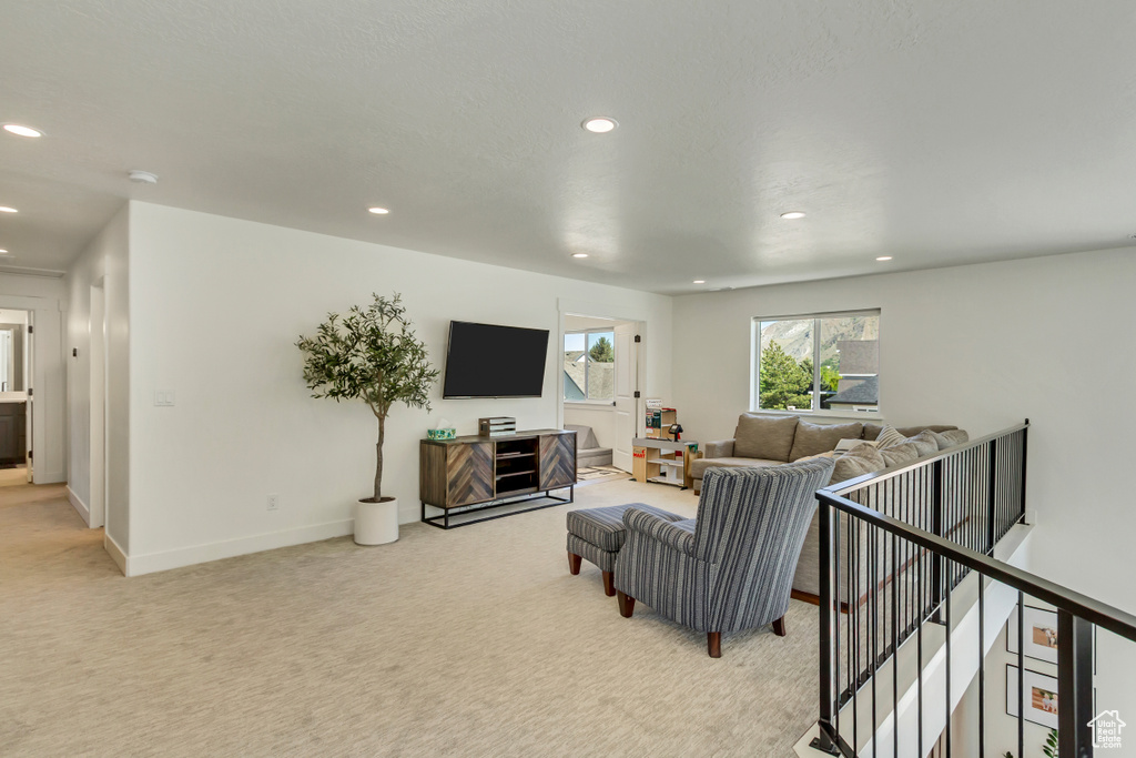 Living area featuring light colored carpet, recessed lighting, and baseboards