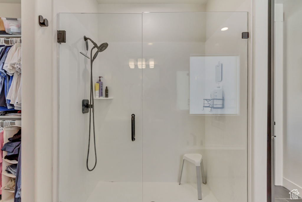 Bathroom with a shower stall and a walk in closet