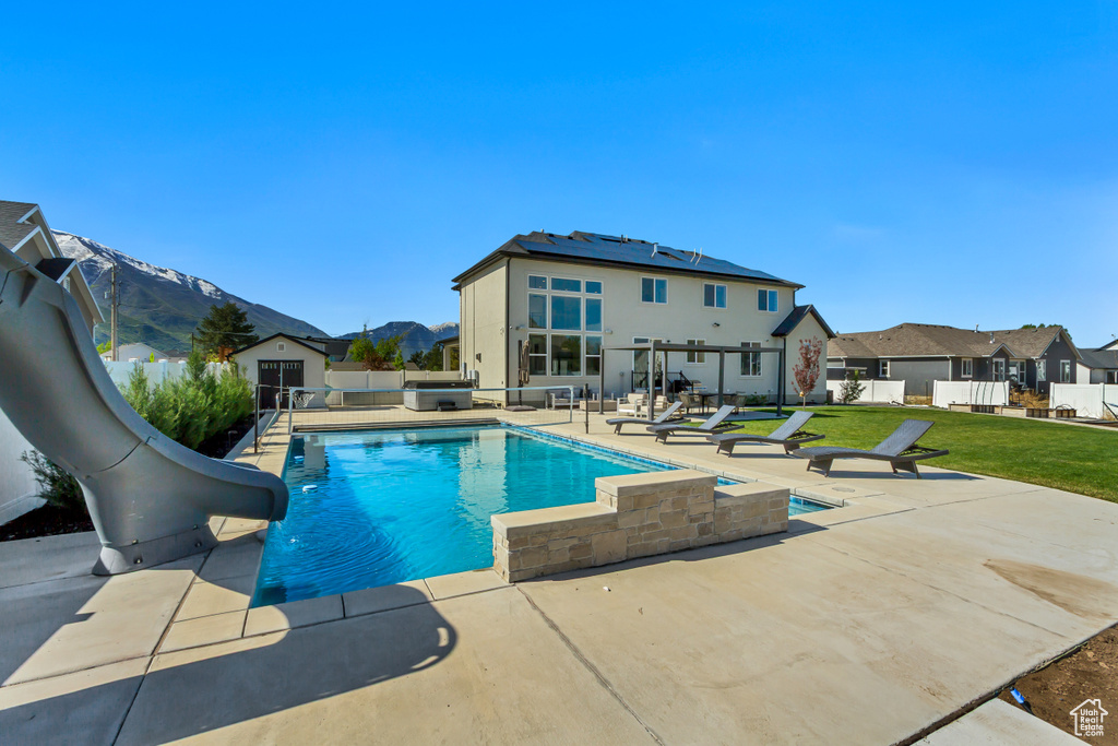 View of swimming pool with a water slide, a patio, an outbuilding, a residential view, and a shed