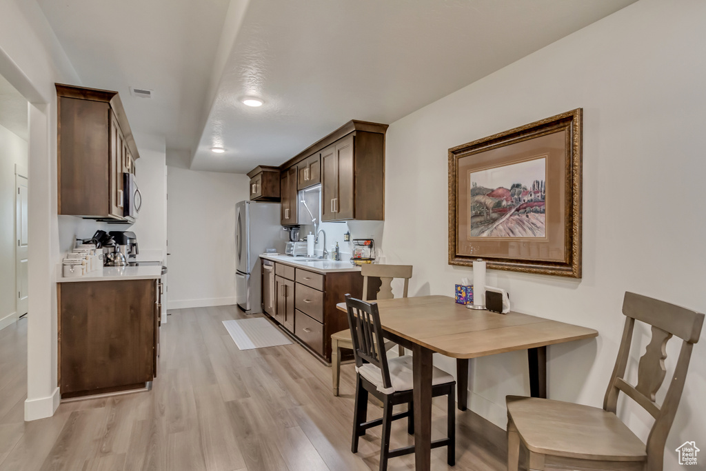 Dining space with light wood-style flooring and baseboards