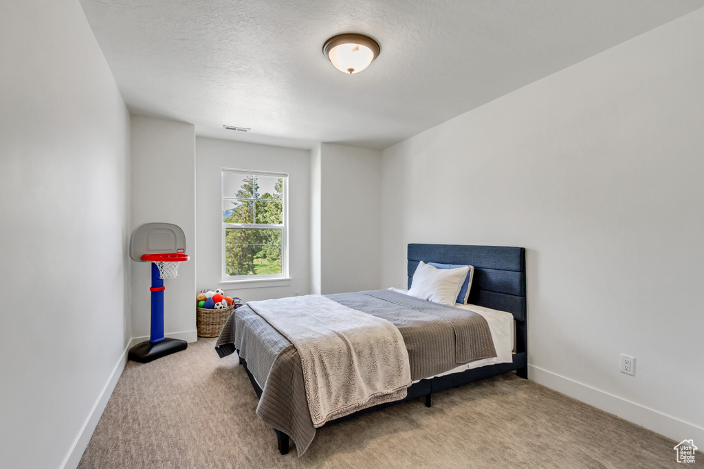 Carpeted bedroom with baseboards and a textured ceiling