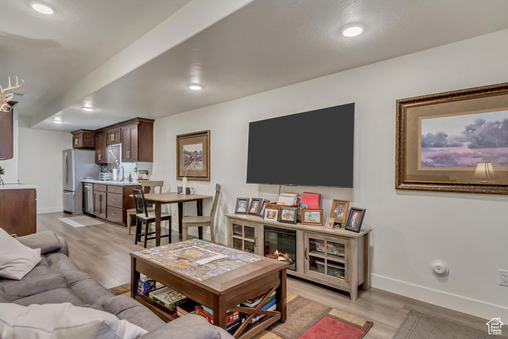 Living area with light wood-type flooring, baseboards, and recessed lighting