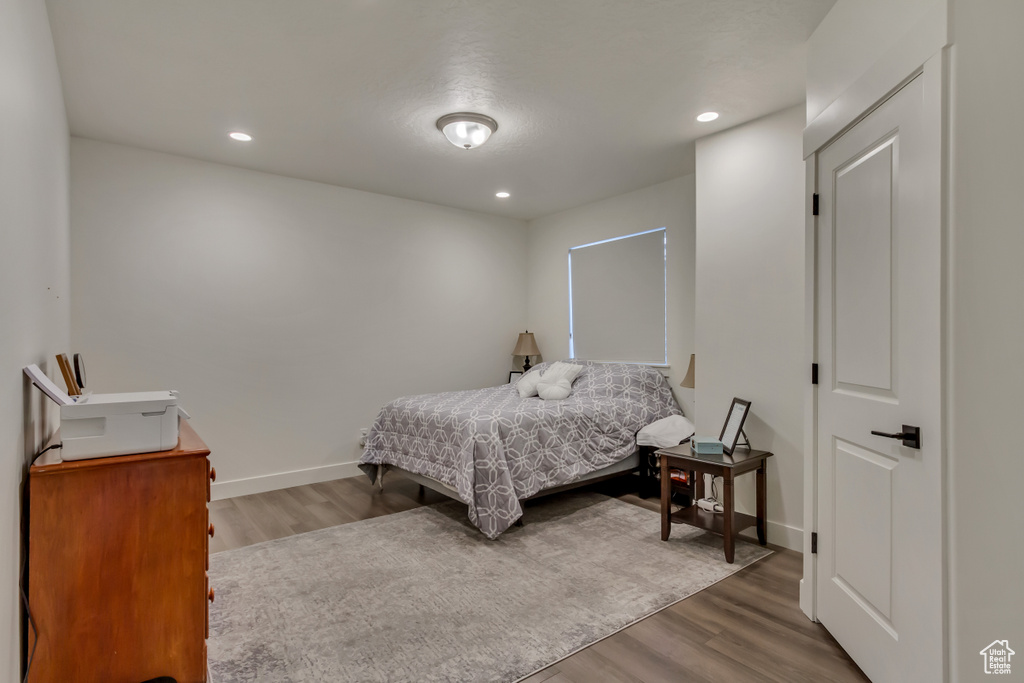 Bedroom with wood finished floors, recessed lighting, and baseboards
