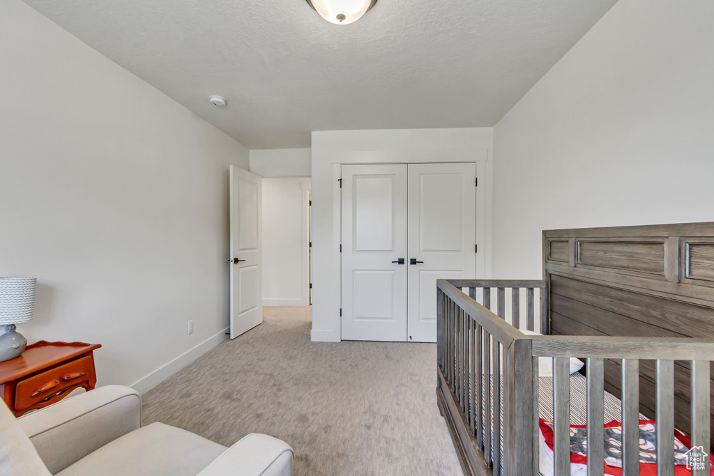 Carpeted bedroom featuring baseboards and a closet