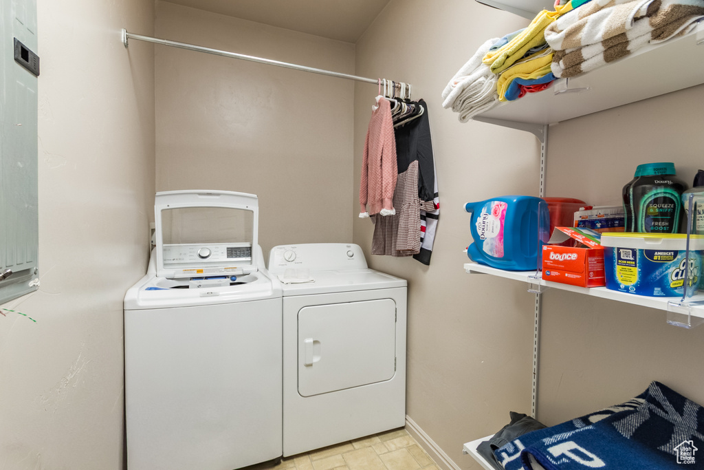 Clothes washing area featuring washer and dryer and baseboards