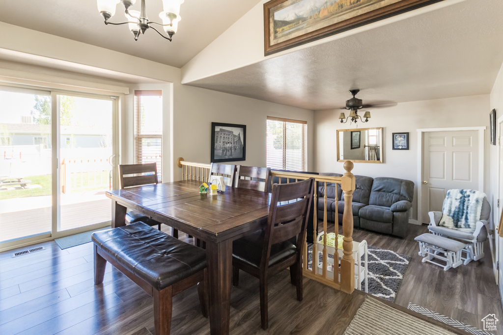 Dining room with a chandelier, lofted ceiling, wood finished floors, and ceiling fan