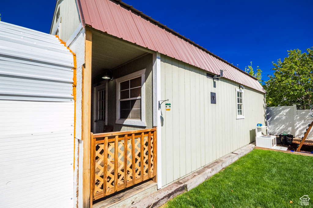 View of side of home with metal roof and a lawn