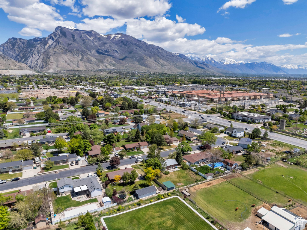 Aerial view of property and surrounding area featuring mountains, property boundaries highlighted, and nearby suburban area