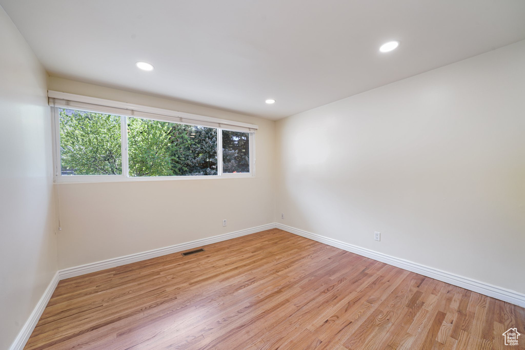 Spare room featuring healthy amount of natural light, baseboards, wood finished floors, and recessed lighting