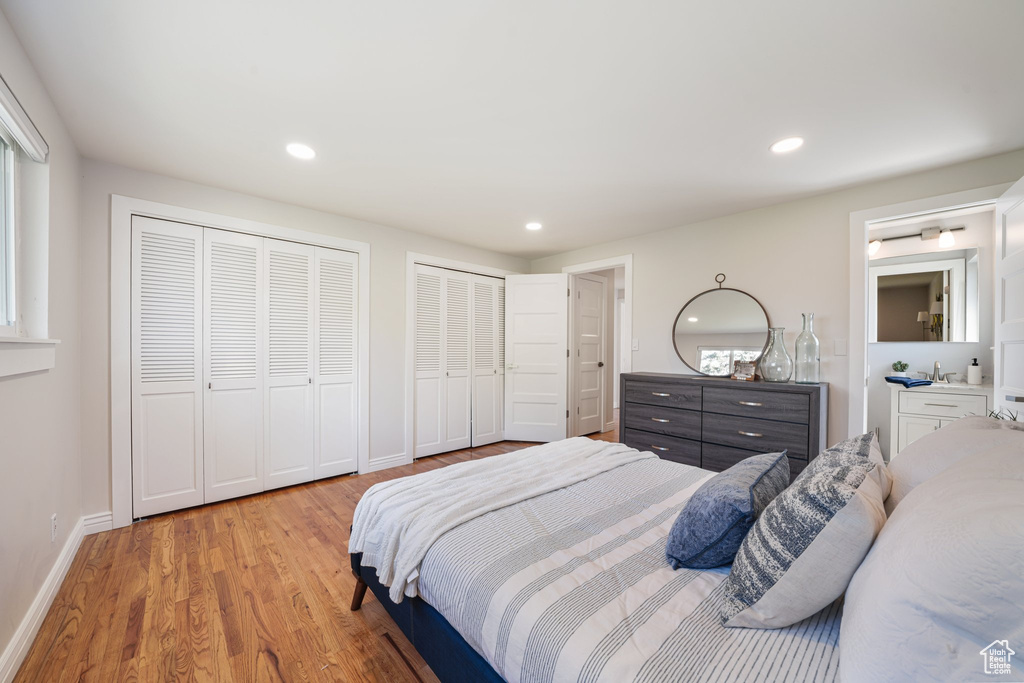 Bedroom featuring two closets, light wood finished floors, baseboards, and recessed lighting