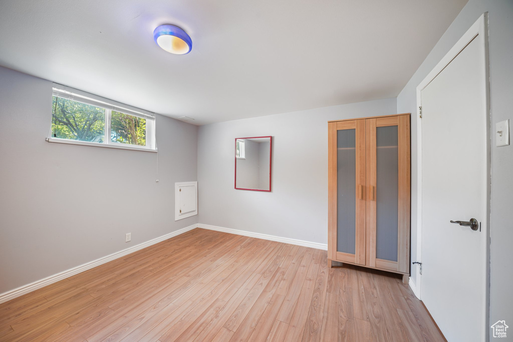 Unfurnished bedroom featuring light wood finished floors and baseboards