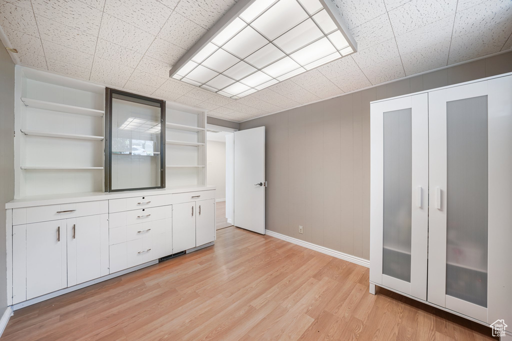 Unfurnished living room featuring light wood finished floors and baseboards