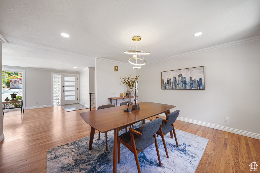 Dining space featuring ornamental molding, baseboards, light wood-style flooring, recessed lighting, and a chandelier