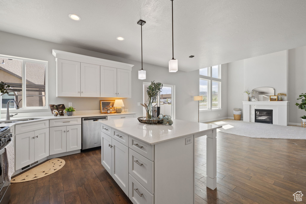 Kitchen featuring dishwasher, a sink, white cabinetry, dark wood finished floors, and light countertops